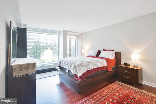 bedroom with baseboards and wood finished floors