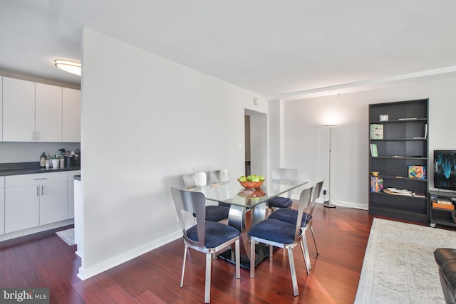 dining area with baseboards and dark wood-style flooring