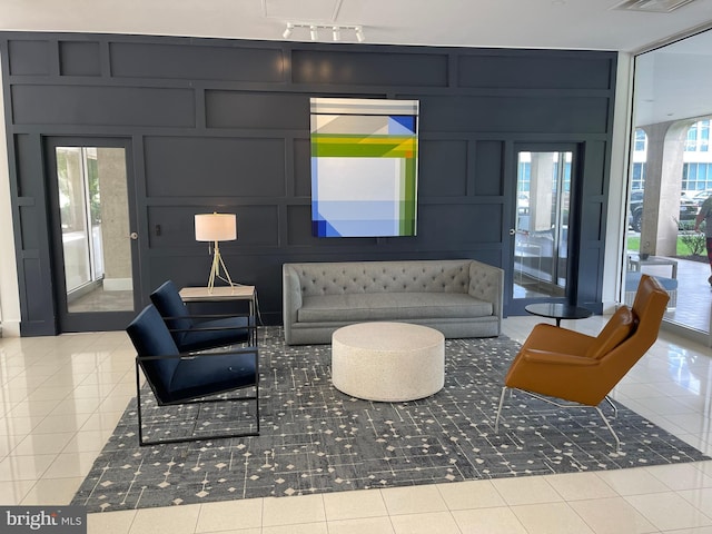 tiled living room with rail lighting, plenty of natural light, and a decorative wall