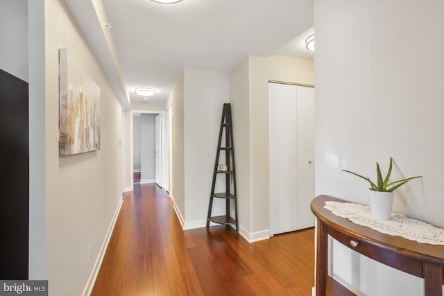 hall featuring baseboards and wood finished floors