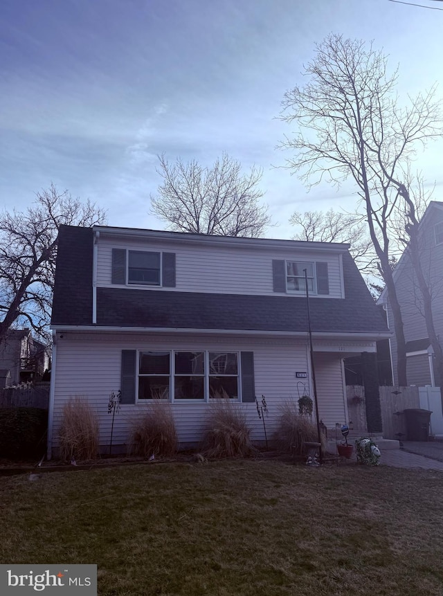 view of front of home featuring a front lawn and roof with shingles