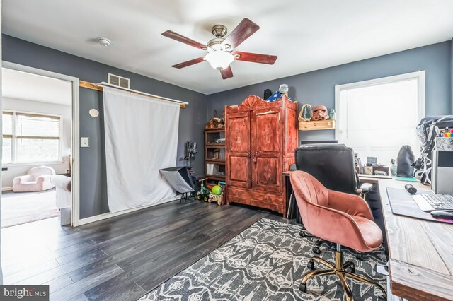 office area with wood finished floors, visible vents, and ceiling fan