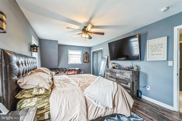 bedroom with a ceiling fan, a closet, baseboards, and wood finished floors