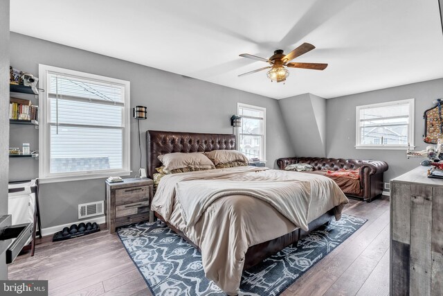bedroom with visible vents, multiple windows, and wood-type flooring