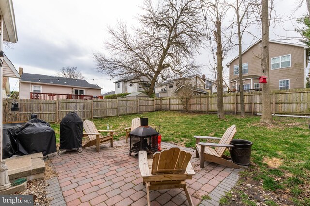 view of patio with a fenced backyard, a fire pit, a residential view, and grilling area