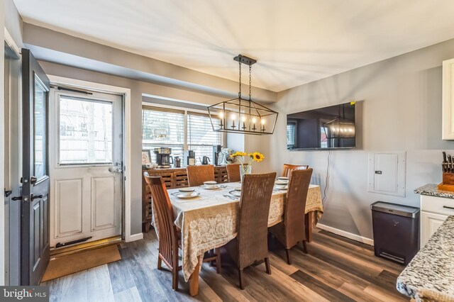 dining space with a notable chandelier, baseboards, and dark wood finished floors