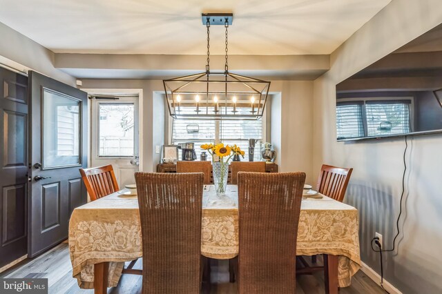 dining space featuring wood finished floors and an inviting chandelier
