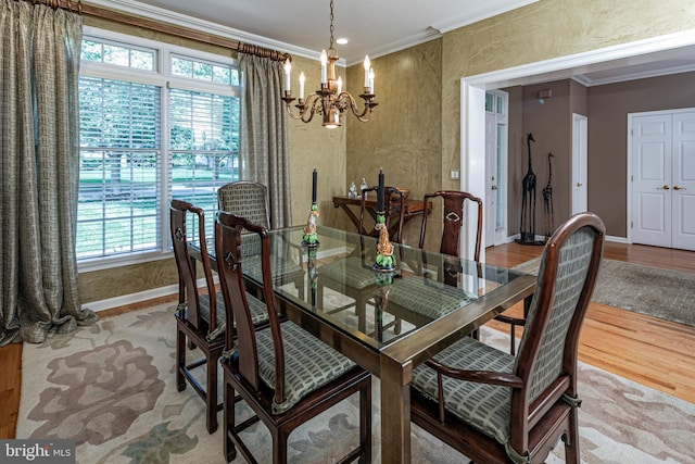 dining space with a chandelier, baseboards, ornamental molding, and wood finished floors
