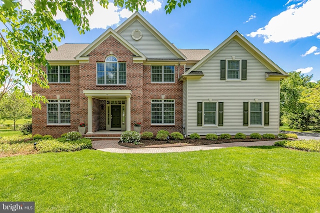colonial-style house with a front yard and brick siding