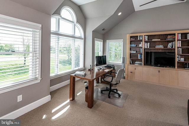 office area featuring vaulted ceiling, light carpet, and baseboards