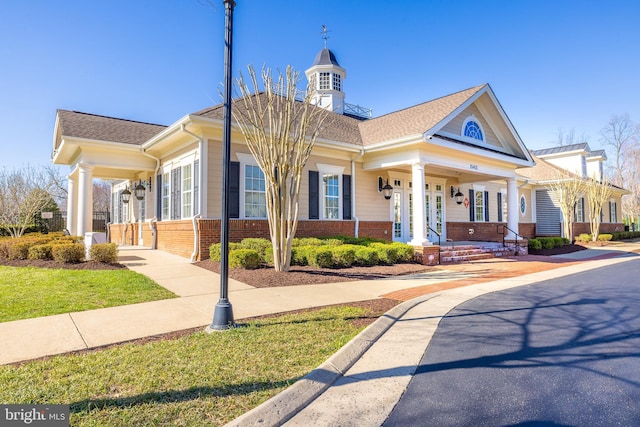 view of front facade featuring brick siding and covered porch
