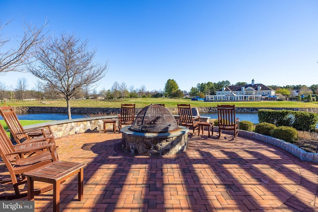 view of patio featuring an outdoor fire pit and a water view