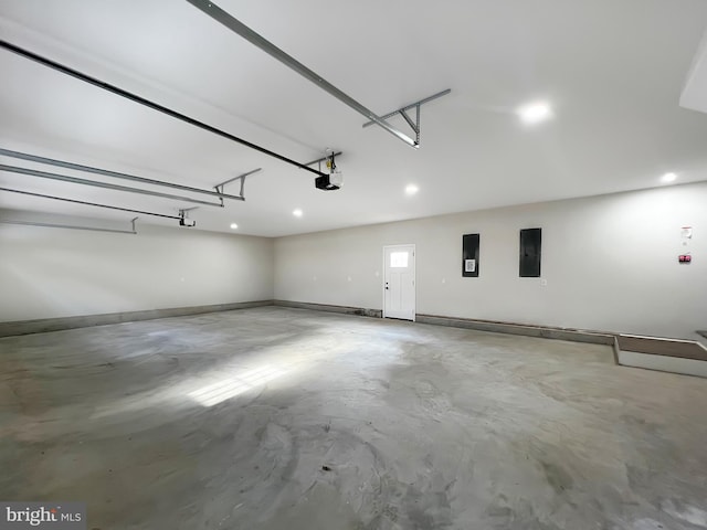 garage with recessed lighting, baseboards, a garage door opener, and electric panel