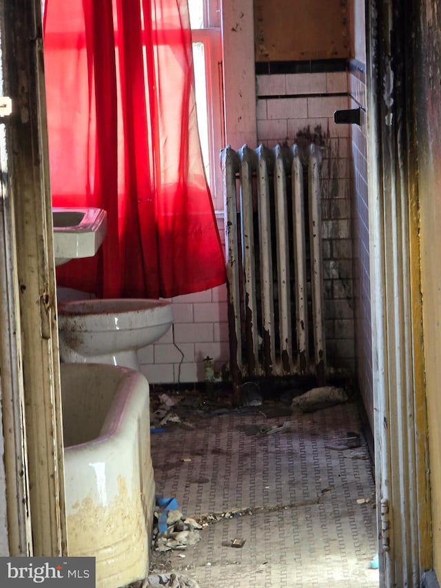 1930 Wilkens Ave, Baltimore, MD 21223 - bathroom with tile walls, toilet, and radiator heating unit