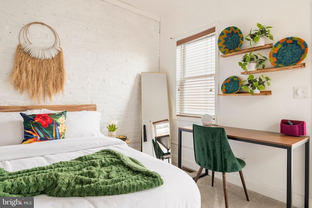 bedroom with baseboards, brick wall, and carpet