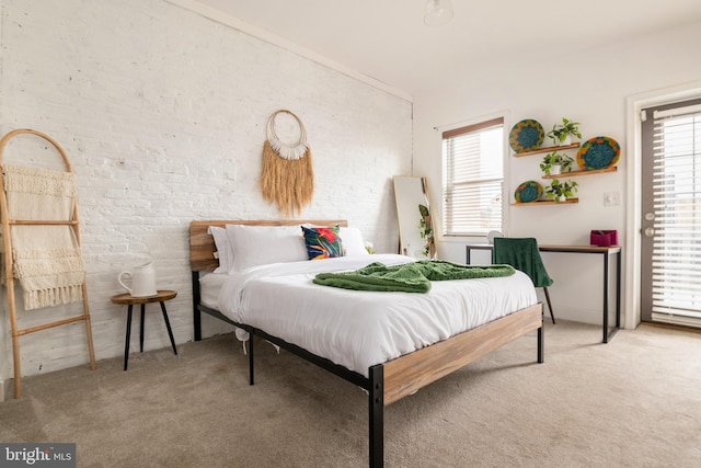 bedroom featuring brick wall and carpet flooring