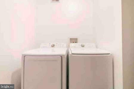 clothes washing area featuring washing machine and dryer and laundry area