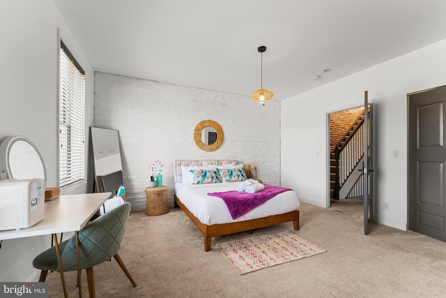 bedroom with baseboards, carpet floors, and brick wall