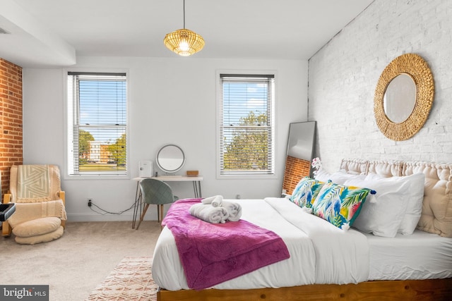 bedroom featuring carpet floors, brick wall, and visible vents
