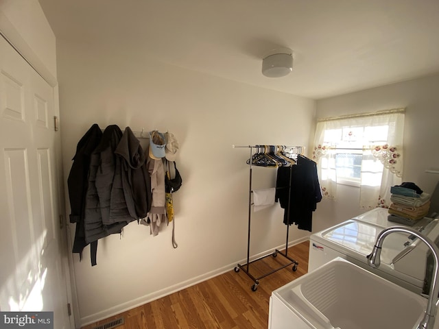 laundry room featuring visible vents, baseboards, wood finished floors, washer / dryer, and laundry area