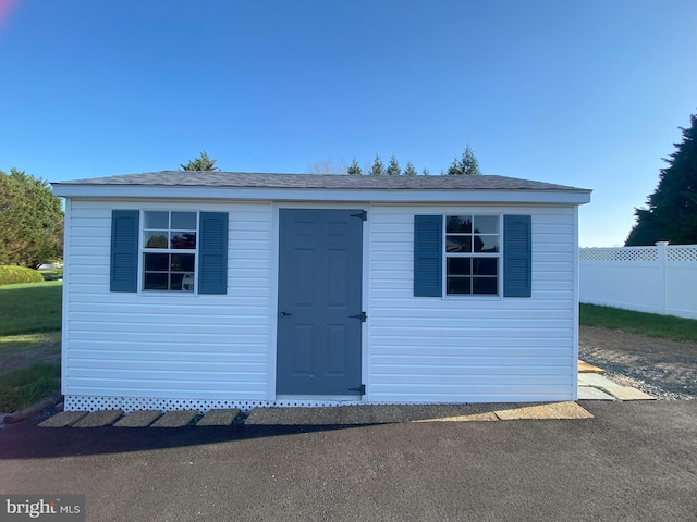view of shed featuring fence