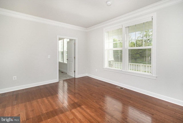 unfurnished bedroom featuring baseboards, ornamental molding, wood finished floors, and multiple windows