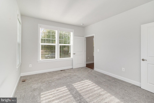 unfurnished bedroom featuring visible vents, baseboards, and carpet floors