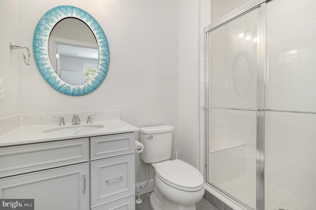 bathroom with toilet, vanity, and a stall shower