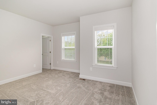 spare room with visible vents, carpet flooring, and baseboards
