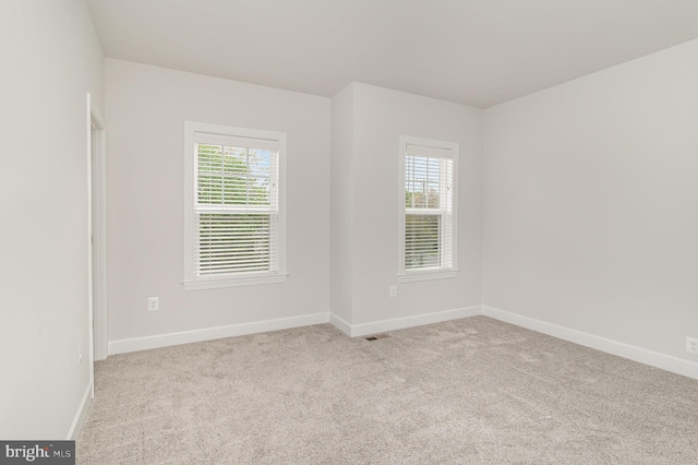 carpeted spare room featuring baseboards