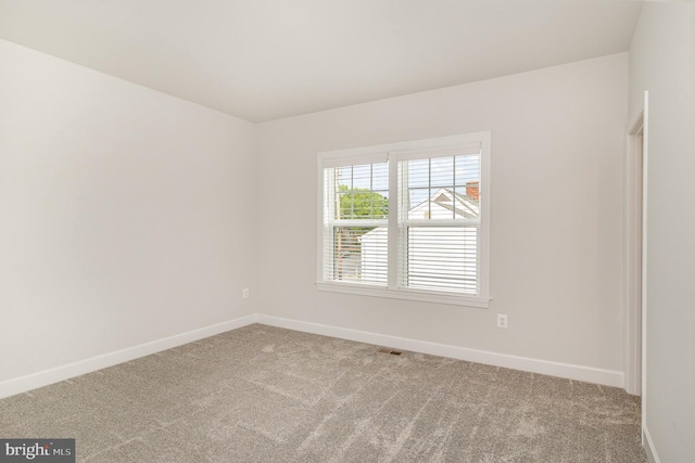 carpeted empty room featuring visible vents and baseboards