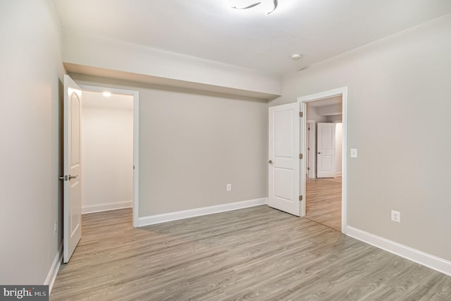 interior space featuring baseboards and light wood finished floors