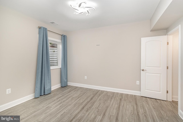 unfurnished bedroom featuring baseboards, visible vents, and light wood-style flooring