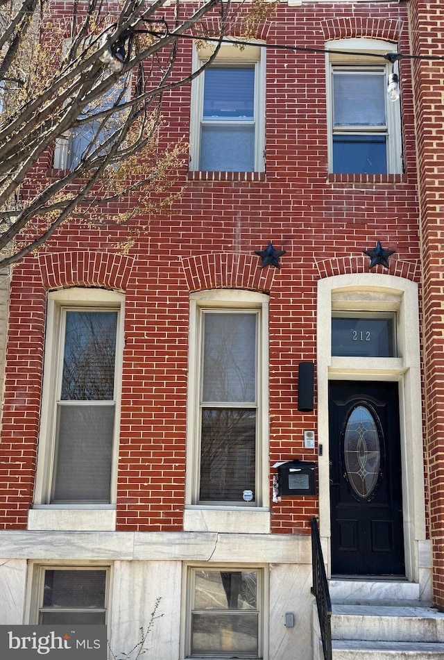 entrance to property featuring brick siding