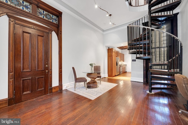 foyer entrance featuring stairs, crown molding, baseboards, and hardwood / wood-style flooring