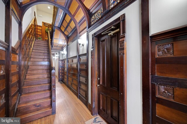 interior space with arched walkways, vaulted ceiling, and wood-type flooring