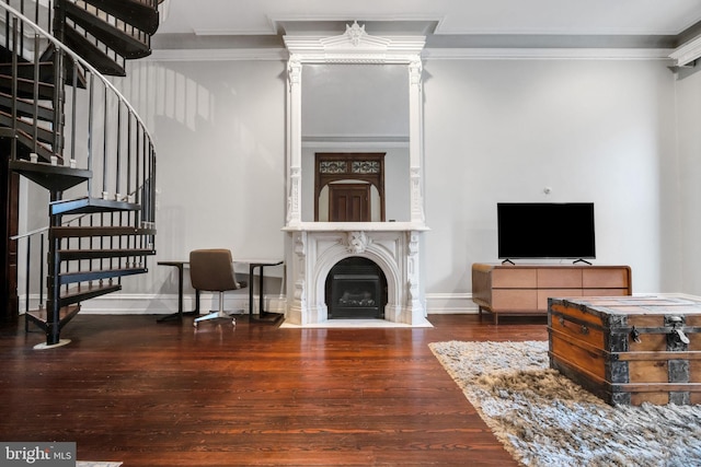 living area with ornamental molding, wood finished floors, and stairway