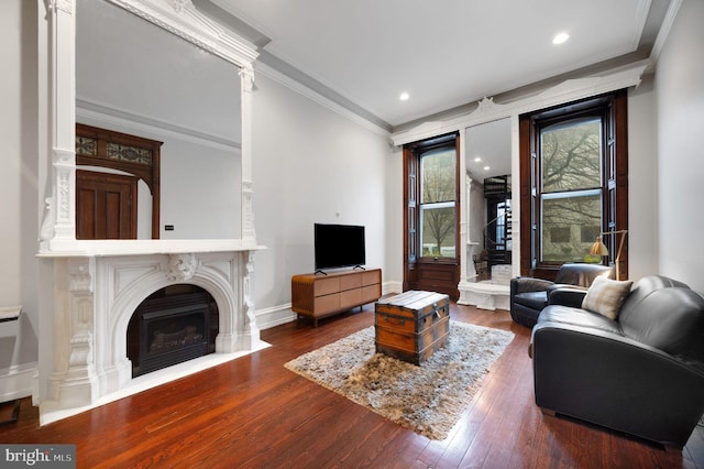 living area featuring crown molding, recessed lighting, hardwood / wood-style floors, baseboards, and a fireplace