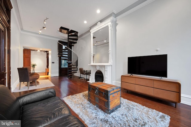 living room featuring baseboards, wood finished floors, ornamental molding, and stairway