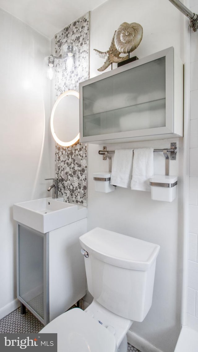bathroom featuring tasteful backsplash and toilet