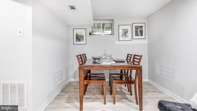 dining area with baseboards, light wood-type flooring, and visible vents
