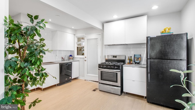 kitchen featuring recessed lighting, white cabinets, tasteful backsplash, light wood finished floors, and black appliances