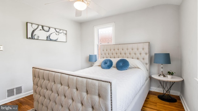 bedroom featuring baseboards, ceiling fan, wood finished floors, and visible vents