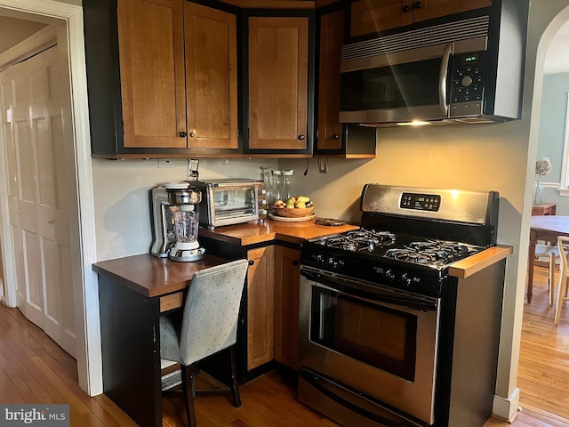 1500 Yardley Newtown Rd, Yardley, PA 19067 - kitchen featuring hardwood / wood-style flooring, arched walkways, appliances with stainless steel finishes, and butcher block counters