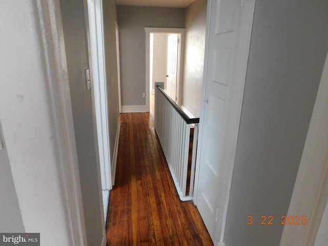 hallway featuring baseboards and dark wood-type flooring