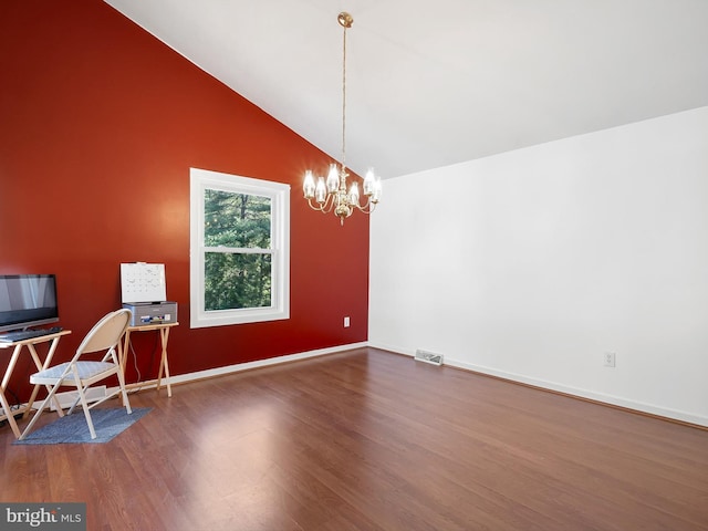 unfurnished dining area featuring visible vents, a notable chandelier, wood finished floors, baseboards, and lofted ceiling