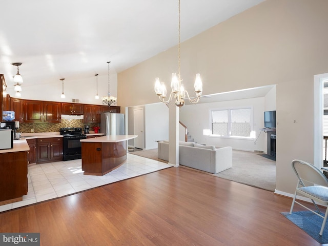kitchen with an inviting chandelier, light countertops, electric range, and high vaulted ceiling