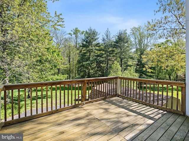 wooden terrace featuring a lawn