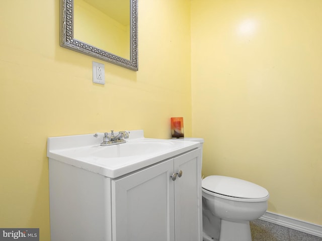 bathroom with vanity, baseboards, and toilet