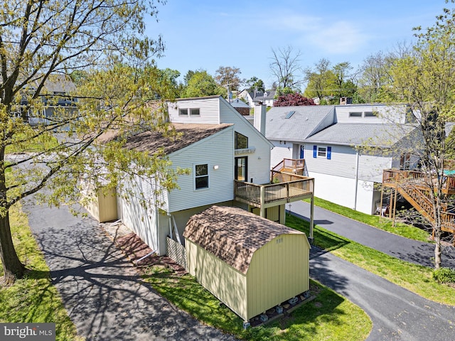 back of house featuring a wooden deck and a residential view